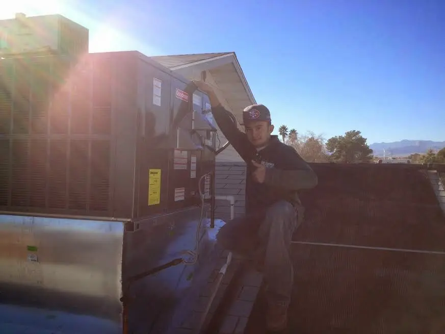 HVAC technician performing Heat Pump Repair on a rooftop unit in Puyallup